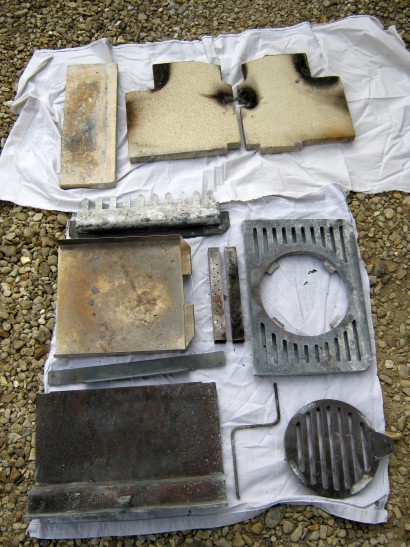 Multifuel grate, vermiculite firebricks and other internal stove parts ready for cleaning