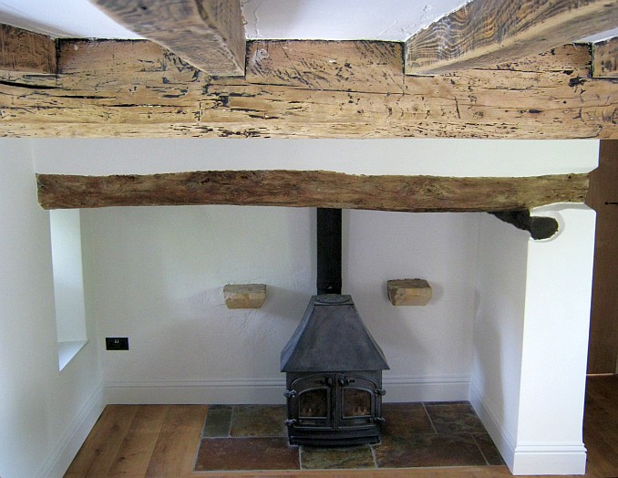 Very old, large woodburning stove in inglenook fireplace before removal