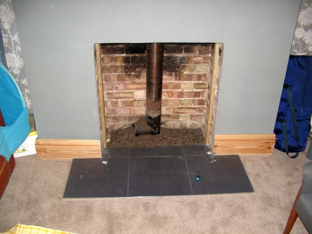 Fireplace opened up to prepare for installation of a new multifuel stove and liner