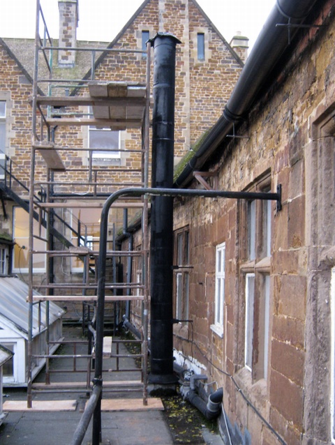 Old metal twin wall chimney serving open fire before replacement with new stainless steel system chimney by Fotheringhay Woodburners