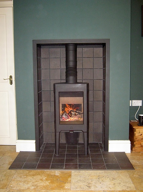 New efficient Jotul F163 woodburning stove installed in the black tiled fireplace by Fotheringhay Woodburners HETAS installer