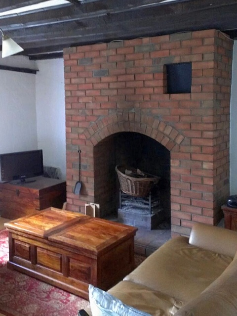 Modern red brick fireplace will be altered to install a new efficient wood stove by Fotheringhay Woodburners