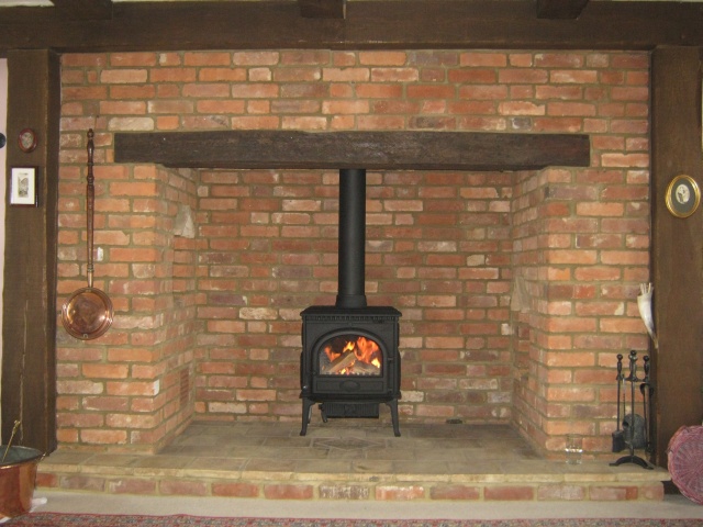 New efficient Jotul F3 MF installed by Fotheringhay Woodburners in red brick inglenook with new stainless steel chimney liner